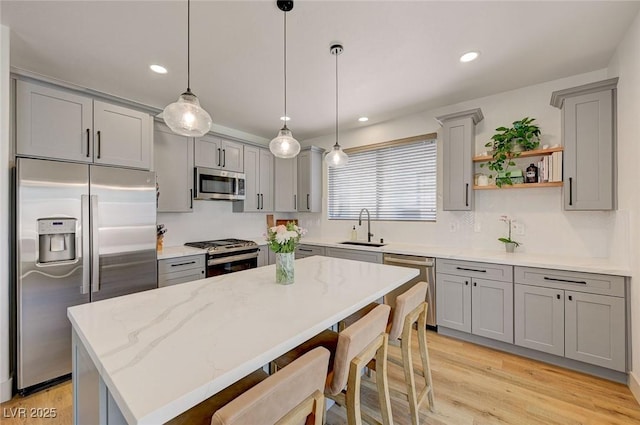 189 Andada Dr, Henderson, NV 89012 - kitchen with appliances with stainless steel finishes, gray cabinets, open shelves, a kitchen island, and a kitchen breakfast bar
