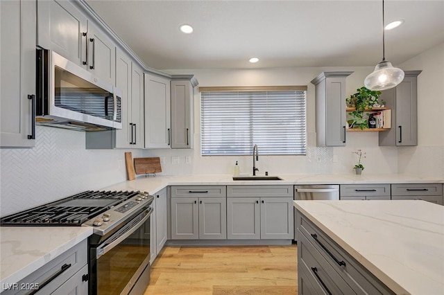 189 Andada Dr, Henderson, NV 89012 - kitchen with appliances with stainless steel finishes, gray cabinets, light wood-type flooring, tasteful backsplash, and recessed lighting