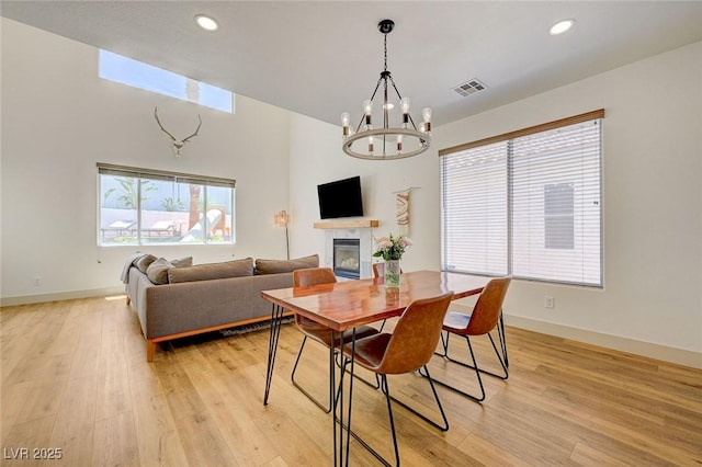 189 Andada Dr, Henderson, NV 89012 - dining area with a chandelier, light wood finished floors, a fireplace, and recessed lighting