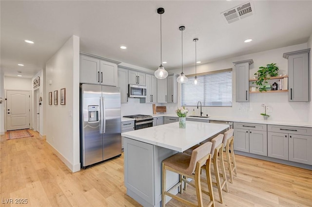 189 Andada Dr, Henderson, NV 89012 - kitchen featuring stainless steel appliances, gray cabinetry, light wood-style floors, open shelves, and recessed lighting