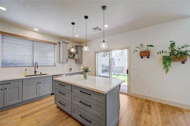 189 Andada Dr, Henderson, NV 89012 - kitchen featuring gray cabinetry, stainless steel dishwasher, light wood-style floors, recessed lighting, and hanging light fixtures