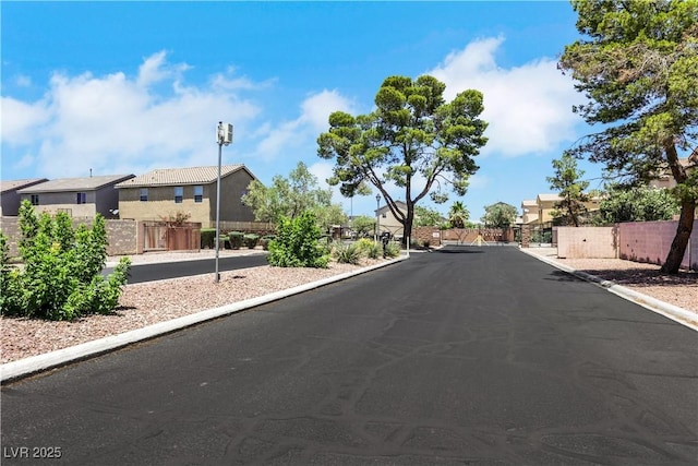 6678 Crystal Run Ln, Las Vegas, NV 89122 - view of asphalt street featuring a residential view, curbs, a gated entry, and a gate