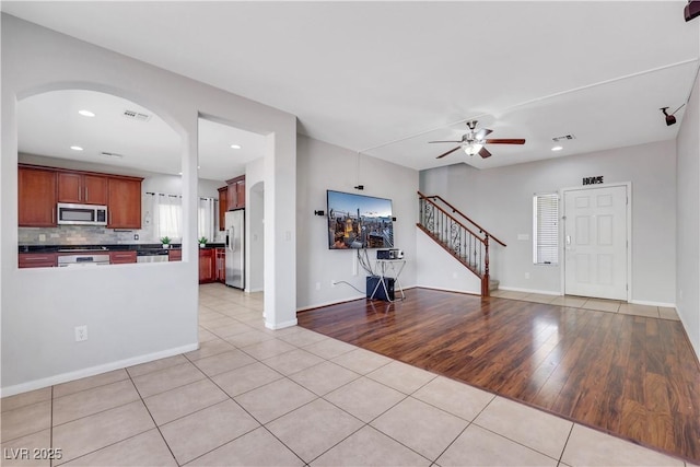 6678 Crystal Run Ln, Las Vegas, NV 89122 - unfurnished living room with light tile patterned floors, ceiling fan, recessed lighting, stairway, and arched walkways