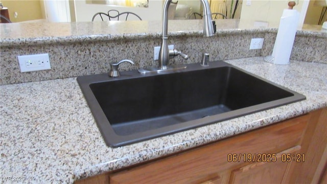 1504 Andrew David Ave, North Las Vegas, NV 89086 - kitchen view of brown cabinets, tasteful backsplash, and light stone counters