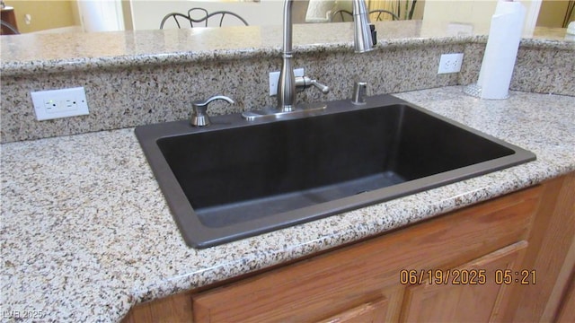 1504 Andrew David Ave, North Las Vegas, NV 89086 - kitchen view of brown cabinetry, tasteful backsplash, and light stone countertops