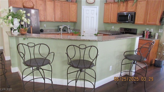 1504 Andrew David Ave, North Las Vegas, NV 89086 - kitchen featuring stainless steel appliances, a breakfast bar area, a large island, and light stone countertops