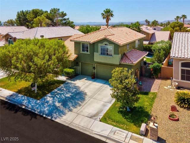 9909 Masked Duck Ave, Las Vegas, NV 89117 - mediterranean / spanish-style home with an attached garage, driveway, stucco siding, and a tile roof