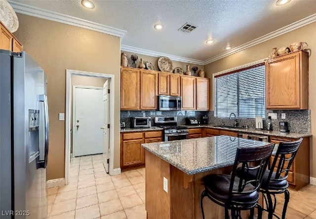8698 Waterford Bend St, Las Vegas, NV 89123 - kitchen featuring stainless steel appliances, decorative backsplash, light tile patterned floors, a breakfast bar, and ornamental molding