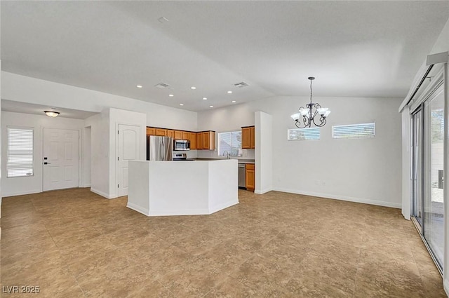 2059 Joy View Ln, Henderson, NV 89012 - kitchen featuring stainless steel appliances, a chandelier, brown cabinets, vaulted ceiling, and open floor plan