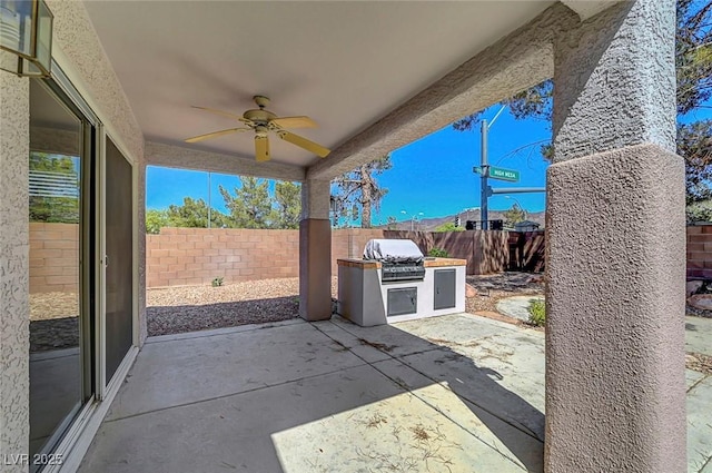 2059 Joy View Ln, Henderson, NV 89012 - fenced backyard with an outdoor kitchen, a ceiling fan, and a patio area