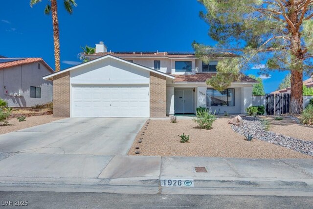 1926 Navarre Ln, Henderson, NV 89014 - view of front of house with an attached garage, solar panels, driveway, stucco siding, and brick siding
