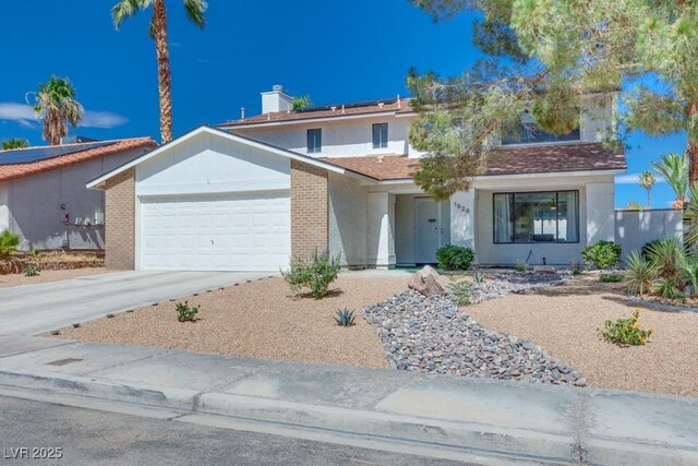1926 Navarre Ln, Henderson, NV 89014 - view of front facade featuring an attached garage, solar panels, concrete driveway, and stucco siding