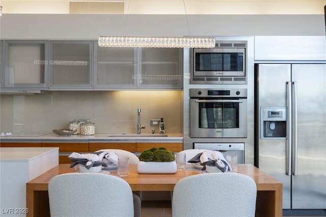 3722 Las Vegas Blvd Unit 2512E, Las Vegas, NV 89158 - kitchen with built in appliances, light countertops, glass insert cabinets, backsplash, and modern cabinets