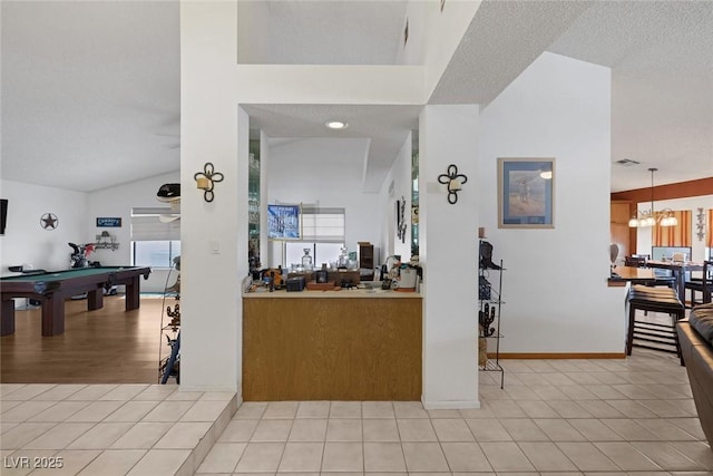 9100 Shelter Cove Ct, Las Vegas, NV 89117 - bar featuring healthy amount of natural light, pool table, light tile patterned floors, vaulted ceiling, and a textured ceiling