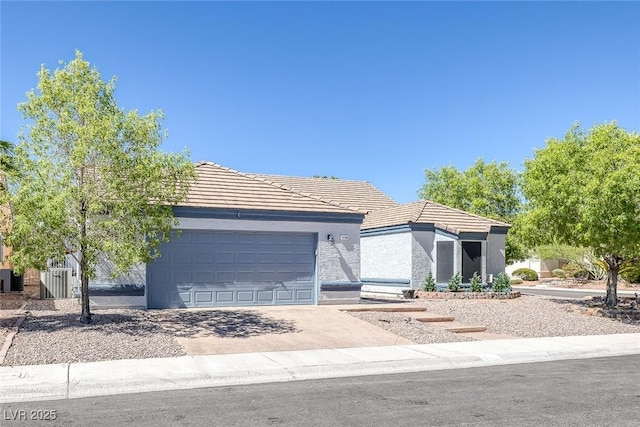 9100 Shelter Cove Ct, Las Vegas, NV 89117 - view of front of house featuring a garage, driveway, a tile roof, and stucco siding