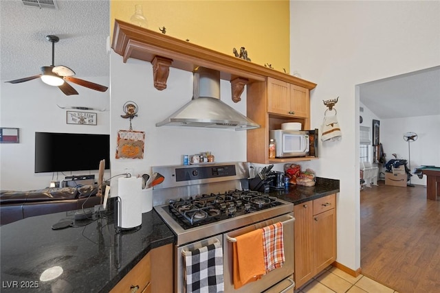 9100 Shelter Cove Ct, Las Vegas, NV 89117 - kitchen with stainless steel appliances, wall chimney exhaust hood, open floor plan, and ceiling fan