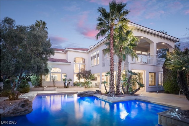 2041 Troon Dr, Henderson, NV 89074 - rear view of house with a balcony, a patio area, stucco siding, and an outdoor pool