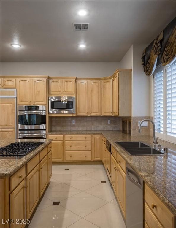 2041 Troon Dr, Henderson, NV 89074 - kitchen with stainless steel appliances, light brown cabinetry, stone counters, tasteful backsplash, and recessed lighting