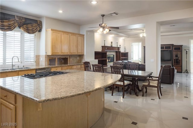 2041 Troon Dr, Henderson, NV 89074 - kitchen featuring light brown cabinets, ceiling fan, recessed lighting, open floor plan, and light stone counters