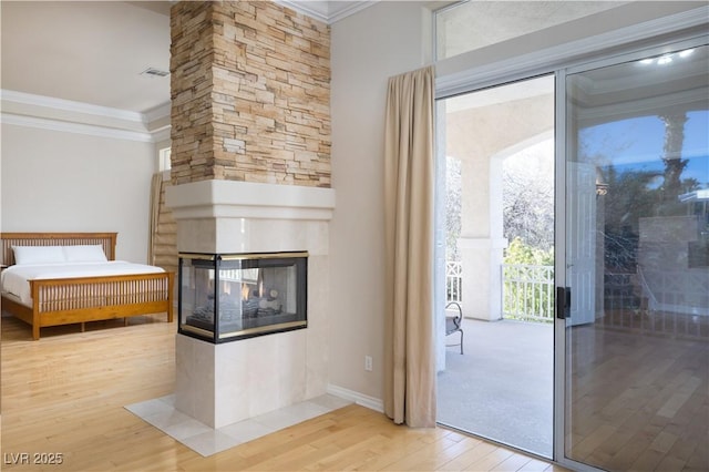 2041 Troon Dr, Henderson, NV 89074 - unfurnished bedroom with a multi sided fireplace, ornamental molding, access to exterior, and hardwood / wood-style flooring