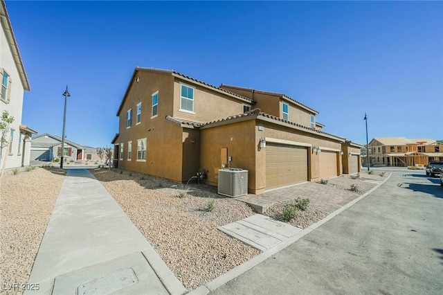 3240 Avernus Ave, Henderson, NV 89044 - view of home's exterior with stucco siding, an attached garage, driveway, a residential view, and a tiled roof