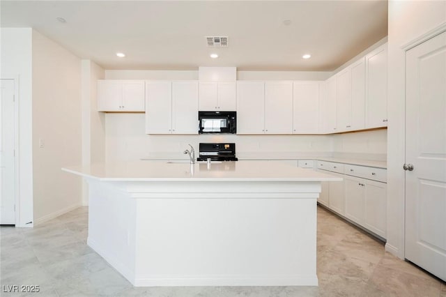 3240 Avernus Ave, Henderson, NV 89044 - kitchen with black microwave, range, a kitchen island with sink, light countertops, and white cabinets