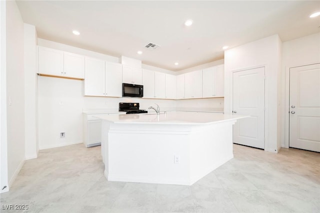 3240 Avernus Ave, Henderson, NV 89044 - kitchen with black microwave, stove, a kitchen island with sink, light countertops, and white cabinetry