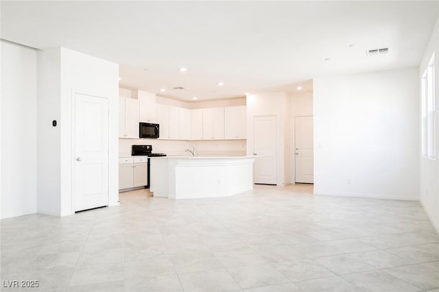3240 Avernus Ave, Henderson, NV 89044 - kitchen with black microwave, stove, light countertops, an island with sink, and open floor plan