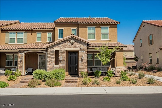 3240 Avernus Ave, Henderson, NV 89044 - view of front of house featuring a tiled roof, a porch, stone siding, and stucco siding
