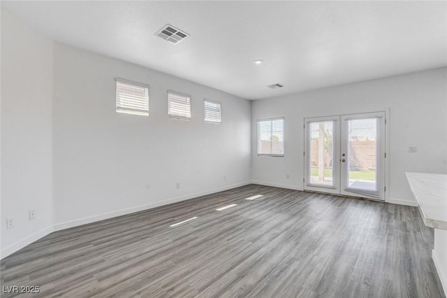 6346 Azurelyn Ave, Las Vegas, NV 89122 - unfurnished room featuring healthy amount of natural light, wood finished floors, and french doors
