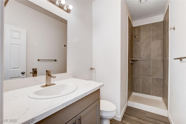 6346 Azurelyn Ave, Las Vegas, NV 89122 - bathroom with vanity, a tile shower, and wood finished floors
