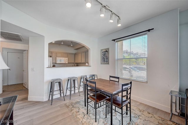 9975 Peace Way Unit 1024, Las Vegas, NV 89147 - dining area featuring rail lighting, light wood finished floors, and arched walkways