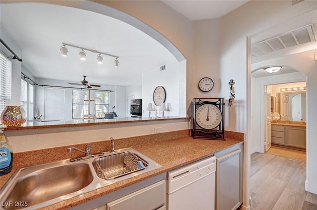 9975 Peace Way Unit 1024, Las Vegas, NV 89147 - kitchen with white dishwasher, arched walkways, ceiling fan, light wood-style flooring, and light countertops