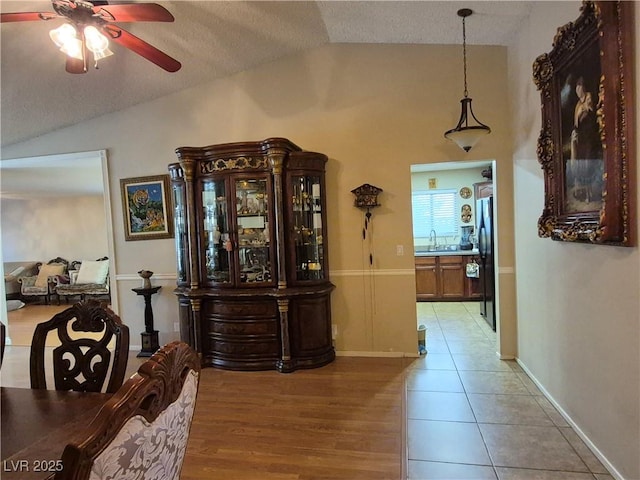 7104 Carrondale Way, Las Vegas, NV 89128 - corridor with vaulted ceiling, light tile patterned floors, and a textured ceiling