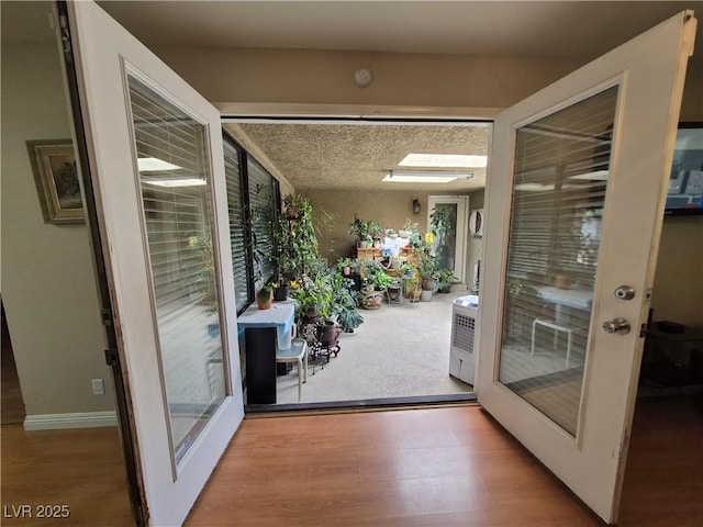 doorway with french doors, wood finished floors, and healthy amount of natural light