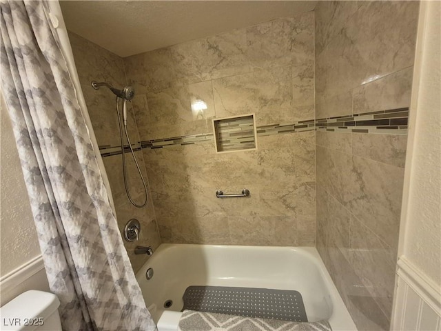 bathroom with shower / bath combination with curtain and toilet