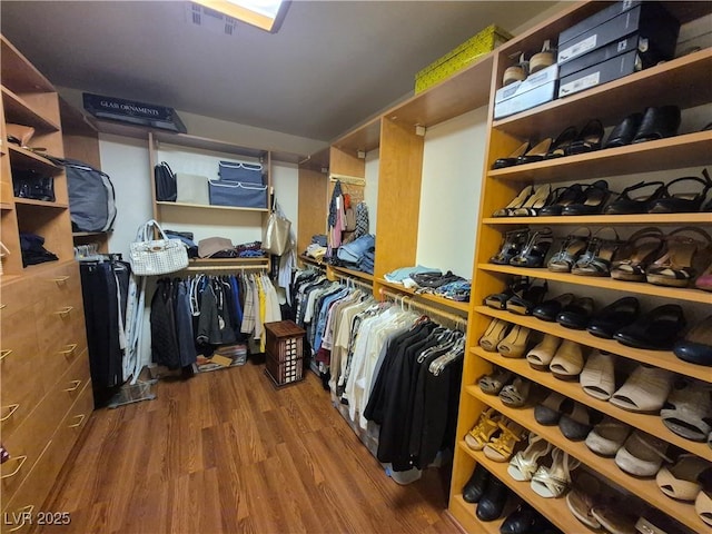 walk in closet with wood finished floors
