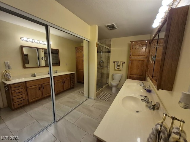 full bath with double vanity, a stall shower, and tile patterned floors