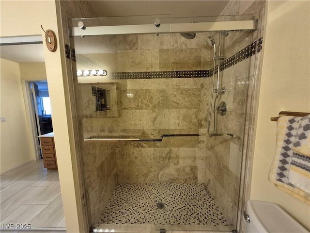 full bath featuring a shower stall and toilet