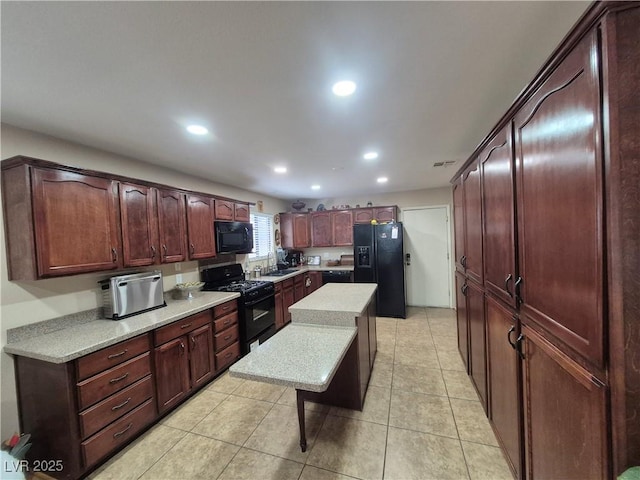 kitchen featuring black appliances, light countertops, recessed lighting, light tile patterned floors, and a kitchen island