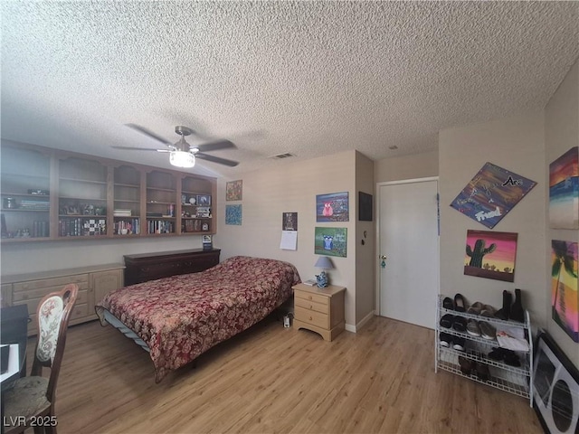 bedroom with light wood finished floors, a textured ceiling, and ceiling fan