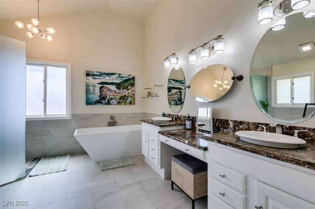 5133 Southern Hills Ln, Las Vegas, NV 89113 - bathroom with vanity, a freestanding bath, plenty of natural light, tile walls, and a chandelier