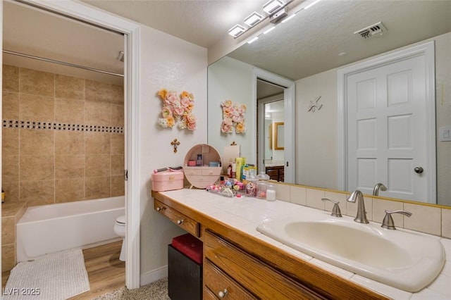 5133 Southern Hills Ln, Las Vegas, NV 89113 - bathroom featuring vanity,  shower combination, a textured ceiling, and wood finished floors