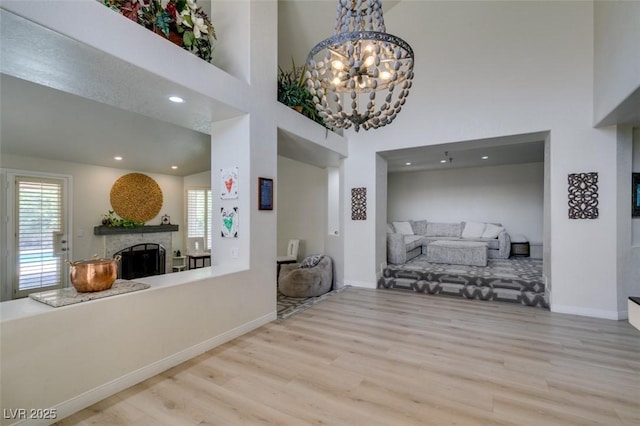 5133 Southern Hills Ln, Las Vegas, NV 89113 - dining space with a fireplace, wood finished floors, healthy amount of natural light, a towering ceiling, and a chandelier