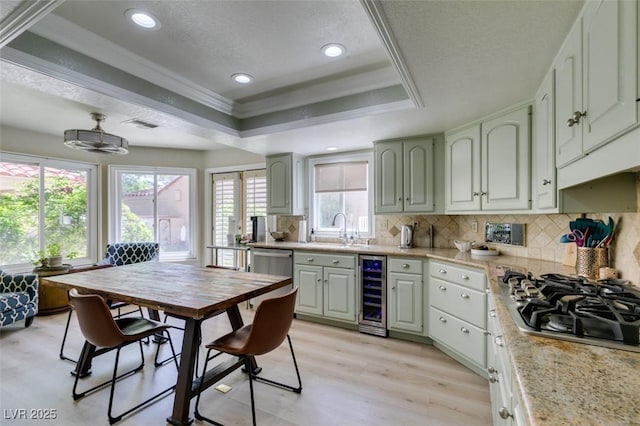 5133 Southern Hills Ln, Las Vegas, NV 89113 - kitchen featuring appliances with stainless steel finishes, beverage cooler, a raised ceiling, tasteful backsplash, and light wood-style flooring