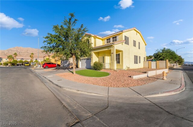 5907 Soft Mist Ct, Las Vegas, NV 89110 - mediterranean / spanish house featuring a garage, stucco siding, a tile roof, and a mountain view