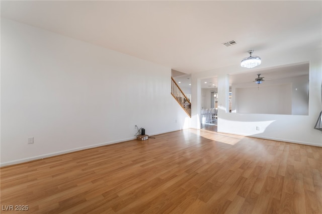 5907 Soft Mist Ct, Las Vegas, NV 89110 - unfurnished living room featuring stairway, light wood finished floors, and ceiling fan