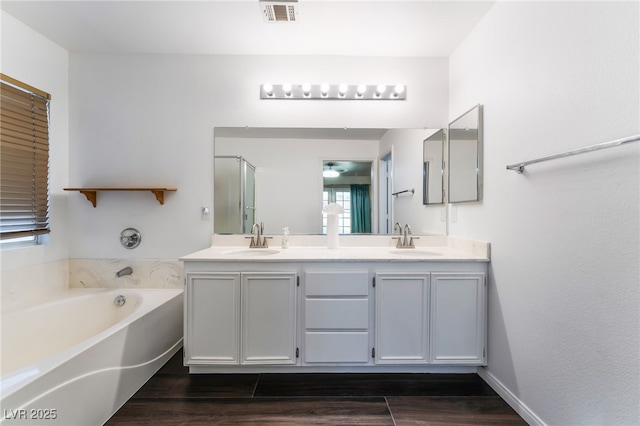 5907 Soft Mist Ct, Las Vegas, NV 89110 - bathroom featuring double vanity, a garden tub, wood finished floors, and a shower