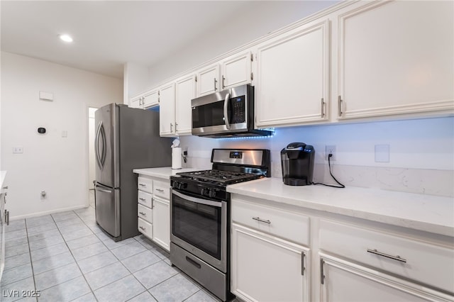 5907 Soft Mist Ct, Las Vegas, NV 89110 - kitchen with stainless steel appliances, white cabinets, light tile patterned floors, light stone countertops, and recessed lighting