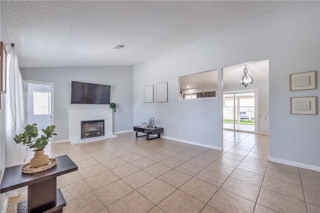 905 Smith St, Las Vegas, NV 89108 - living area featuring vaulted ceiling, healthy amount of natural light, light tile patterned flooring, a brick fireplace, and a textured ceiling